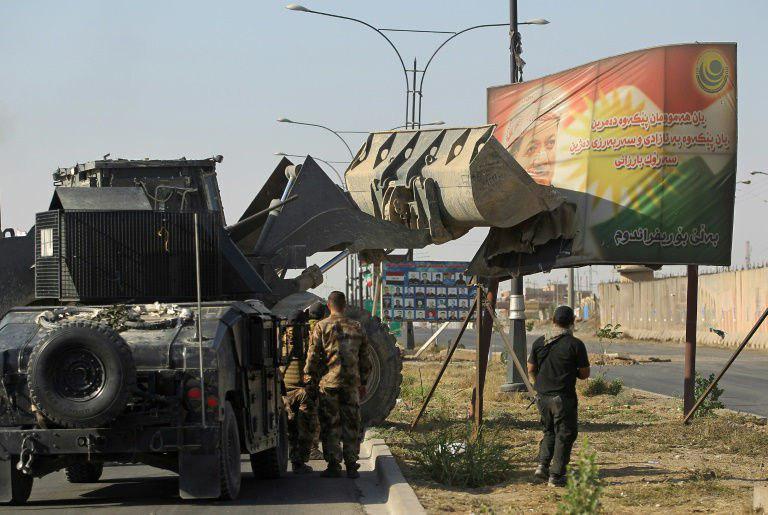 خودروی ارتش عراق در حال برداشتن تصویر مسعود بارزانی در ورودی کرکوک (عکس)