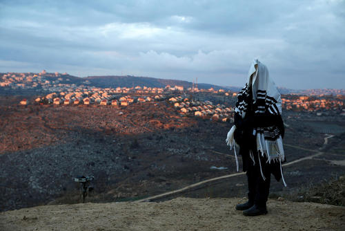 یک یهودی ارتدوکس شهرک نشین در حال انجام مراسم عبادی در کرانه باختری