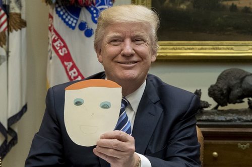 ترامپ نقاشی یک کودک از چهره اش را به دست گرفته است- کاخ سفید