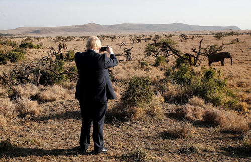 بوریس جانسون وزیر امور خارجه بریتانیا در حال گرفتن عکس با تلفن همراهش از فیل های موجود در منطقه محافظت شده حیات وحش در دست لایکیپیا در شمال کنیا