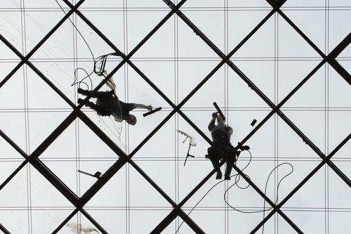 کارگران در حال تمیز کردن شیشه های نمای ساختمان مرکز تجارت جهانی در درسدن آلمان