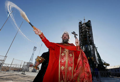 کشیش های ارتدوکس در حال انجام مراسم مذهبی در اطراف فضاپیمای سایوز روسی یک روز پیش از پرتاب آن به فضا – پایگاه فضایی بایکونور قزاقستان