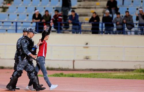 نیروهای امنیتی لبنان یکی از تماشاگران تیم ملی لبنان را به خارج از استادیوم منتقل می کنند