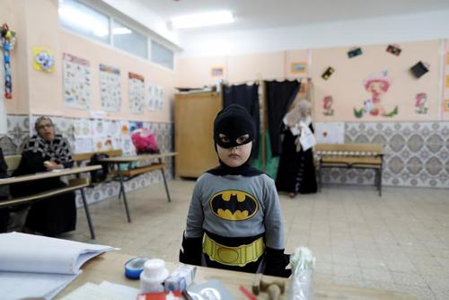 یک پسر بچه در لباس بتمن در یک حوزه رای گیری در انتخابات پارلمانی الجزایر