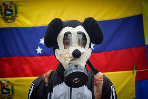مخالفان حکومت ونزوئلا با ماسک های ضد گاز در جریان تظاهرات ضد حکومتی در شهر کاراکاس