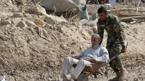 انتقال پیرمردی که توانایی فرار از محل درگیری ندارد توسط سرباز عراقی