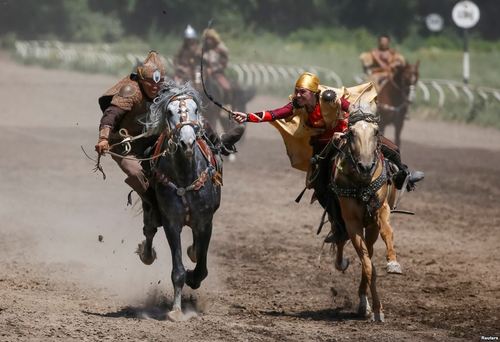 رقابت نزدیک یک سوارکار زن و مرد در مسابقات سنتی اسب سواری در آلماتی قزاقستان