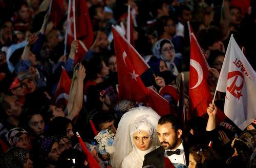 حضور یک عروس و داماد ترکیه ای در مراسم سالگرد شکست کودتای نافرجام ترکیه در مقابل ساختمان پارلمان در آنکارا