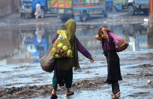دختران پناهجوی افغان در حال جمع آوری میوه های دورریز شده در بازاری در لاهور پاکستان