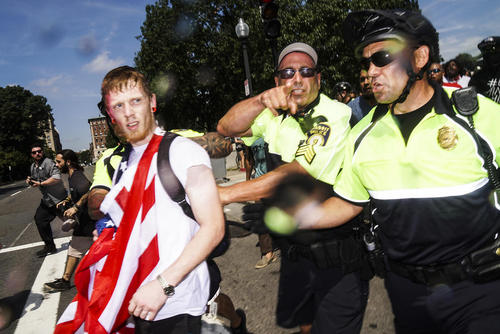 مشایعت یک مرد حامی نژادپرستان از سوی پلیس به بیرون از محل تجمع پس از پایان زودهنگام گردهمایی چند صد نفره آنها