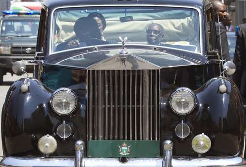 رابرت موگابه رییس جمهور مادام العمر زیمبابوه سوار بر رولز رویس و در حال عزیمت به جلسه پارلمان این کشور در شهر هراره