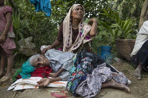 پناهجویان مسلمان میانماری در حال استراحت در کنار جاده در منطقه ای مرزی درون خاک بنگلادش
