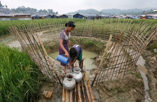 پناهجویان ساکن اردوگاه پناهجویان مسلمان مینماری در بنگلادش در حال جمع آوری آب مصرفی شان از یک گودال آب هستند