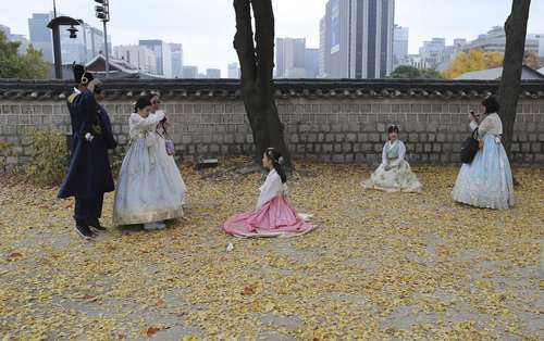 گردشگران کره ای با لباس سنتی در حال گرفتن عکس در کاخی در سئول 