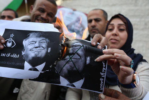 پاره کردن و آتش زدن عکس ترامپ از سوی فلسطینی‌های خشمگین از تصمیم اخیر رییس جمهور آمریکا برای شناسایی شهر قدس به عنوان پایتخت اسراییل