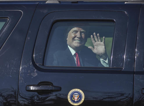 ترامپ در حال دست تکان دادن به حامیانش از داخل خودروی ویژه رییس جمهوری به هنگام رسیدن به 