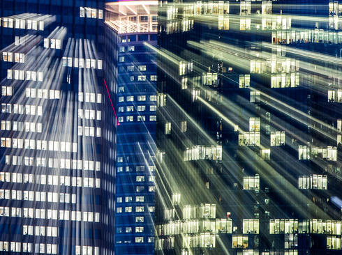 بازتاب نور از شیشه پنجره‌های ساختمان‌ها در شامگاه شهر فرانکفورت آلمان