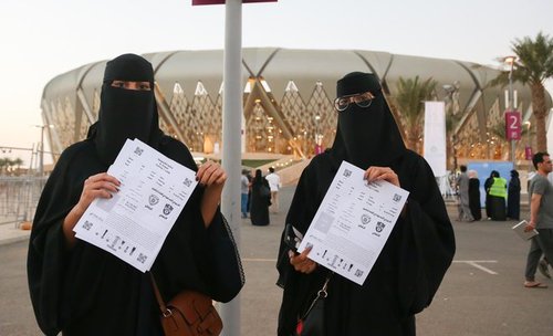 دو خانم سعودی بلیط مسابقه را خریداری کرده اند و با ورزشگاه شهر جده عکس یادگاری انداخته اند.