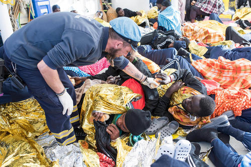 توزیع غذا از سوی امدادرسانان اروپایی به پناهجویان آفریقایی نجات داده شده در دریای مدیترانه