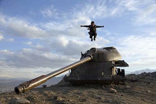 پریدن یک پسربچه از روی یک تانک اسقاط شده روسی در حومه شهر کابل افغانستان/ عکس: آسوشیتدپرس