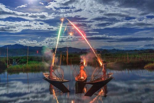 ماهیگیران میانماری در حال نورافشانی در جشنواره نور بودایی‌ها در دریاچه‌ای در میانمار- عکس روز وب سایت 