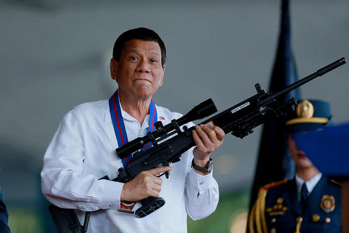 رییس جمهوری جنجالی فیلیپین در آیین تودیع و معارفه رییس جدید پلیس ملی فیلیپین تیربار به دست گرفته است