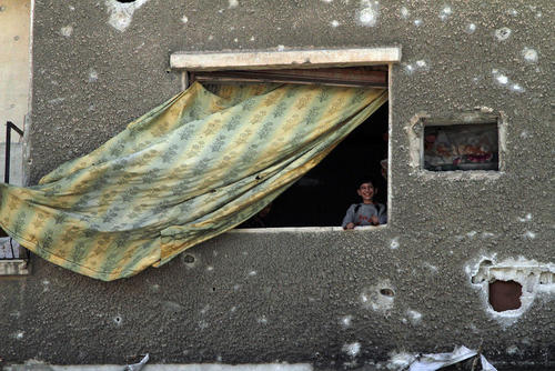 لبخند در خانه‌ای زخمی از گلوله‌های جنگی در شهر جنگ زده دوما در حومه شرقی شهر دمشق سوریه/ عکس: شینهوا