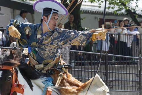 اجرای نمایش یک کماندار روی اسب در لباس سنتی ژاپنی در پارکی در توکیو