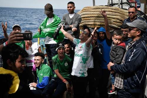 شادمانی پناهجویان مراکشی عازم اروپا در دریای مدیترانه از رسیدن تیم امدادی اروپا در 25 مایلی سواحل لیبی/خبرگزاری فرانسه