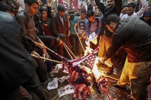 عکس خبرگزاری فرانسه از آتش زدن پرچم آمریکا از سوی گروهی از بسیجی‌ها در مقابل سفارت سابق آمریکا در تهران