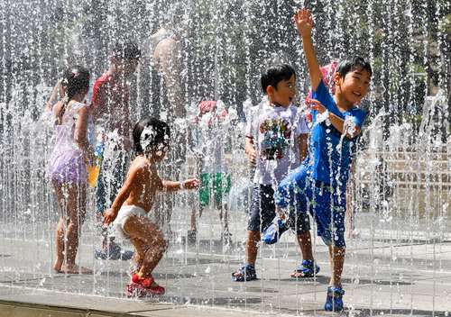 آب بازی کودکان زیر فواره پارکی در شهر توکیو