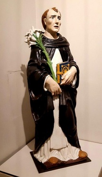 کارگاه خانوادۀ دلا روبیا، مجسمۀ دومینیک قدیس/ فلورانس(ایتالیا)، حدود 1520 میلادی./ گل پخته لعاب‌دار و چند رنگ./ دومینیک قدیس با پوشش سفید و سیاه فرقه دومینیکن که خود در قرن سیزدهم میلادی تاسیس کرد و گل زنبق نماد این فرقه بود. کارگاه خانوادۀ دلا روبیا در قرون پانزدهم و شانزدهم میلادی نوآوریی‌هایی در زمینۀ تولید مجسمه‌های یادبود از جنس گل پخته لعاب‌دار داشت.