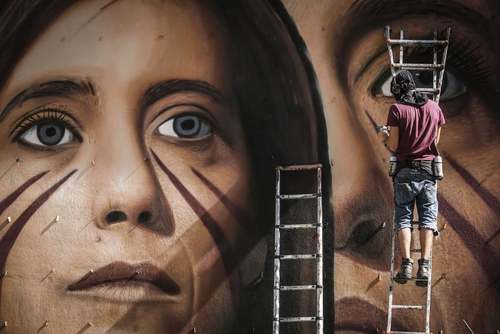 یک هنرمند نقاش در حال کشیدن یک نقاشی دیواری در شهر ناپل ایتالیا