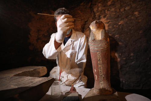 یک باستان شناس مصری در حال کار در یک مقبره تازه کشف شده فراعنه در صحرای جیزه/ خبرگزاری آلمان