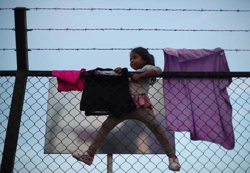 بالا رفتن دختر 5 ساله مهاجر هندوراسی از دیوار مرزی آمریکا و مکزیک/ رویترز
