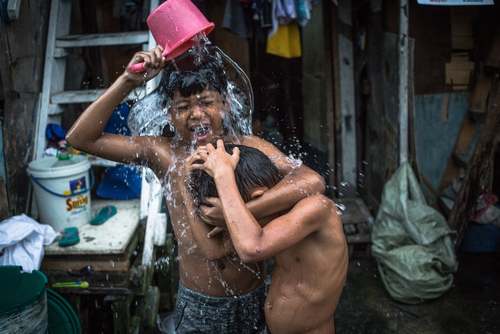 حمام کردن کودکان در منطقه‌ای حاشیه نشین در شهر مانیل فیلیپین/EPA