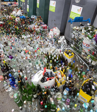 گذاشتن بطری‌های مصرف شده برای بازیافت در مقابل یک مرکز جمع‌آوری وبازیافت بطری‌ها در 