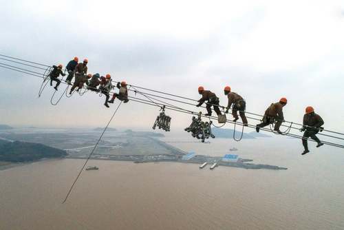 کارگران در حال نصب دکل‌های برق در ارتفاع 380 متری در چین