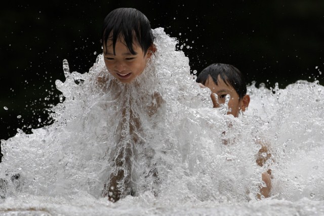 بازی دو کودک ژاپنی در حوض آب نمایی در توکیو