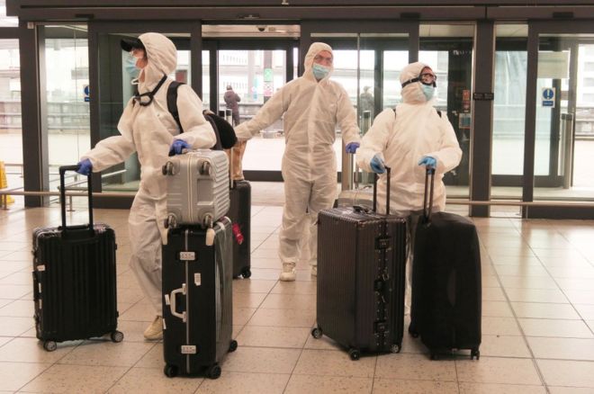مسافران در فرودگاه گاتویک بریتانیا که لباس های ضدکرونا پوشیده اند / Mike Hewitt / Getty images