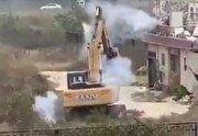 ببینید| یک چینی با ترقه مانع از تخریب خانه‌اش توسط بیل مکانیکی شد