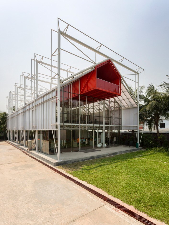 نمای داخلی دفتر مرکزی مدرن The Blues در داکا با طراحی باز، سقف‌های اکسپوز (نمایان) و استفاده بهینه از نور طبیعی در فضای کاری.