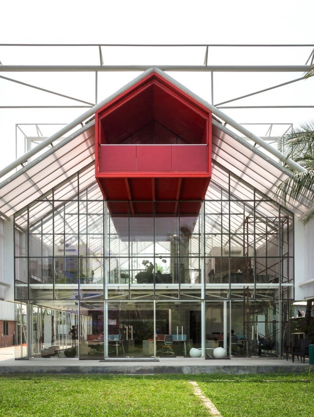 نمای داخلی دفتر مرکزی مدرن The Blues در داکا با طراحی باز، سقف‌های اکسپوز (نمایان) و استفاده بهینه از نور طبیعی در فضای کاری.