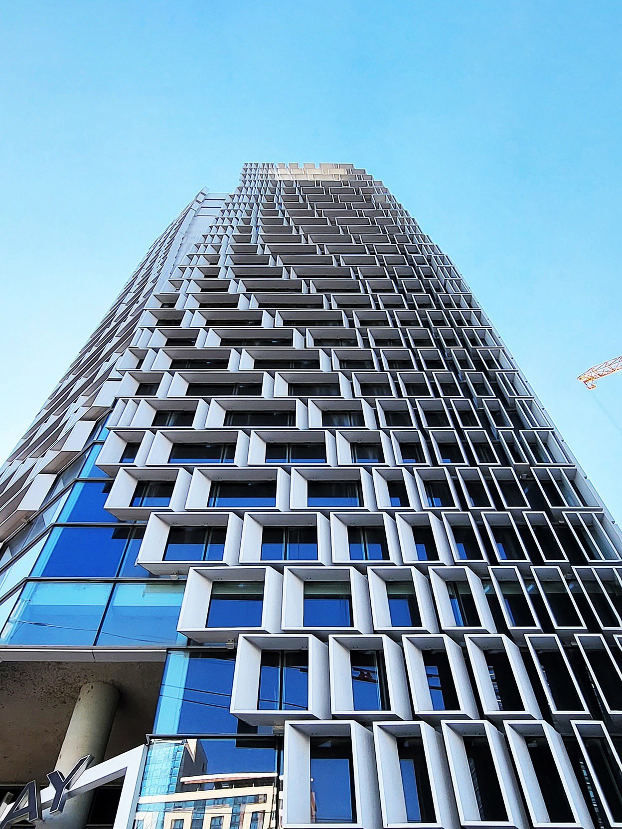 نمای خارجی مدرن و پارامتریک ساختمان HiCC در سئول با واحدهای مدولار خمیده که حسی از حرکت و سیالیت را در معماری تجاری نشان می‌دهد.