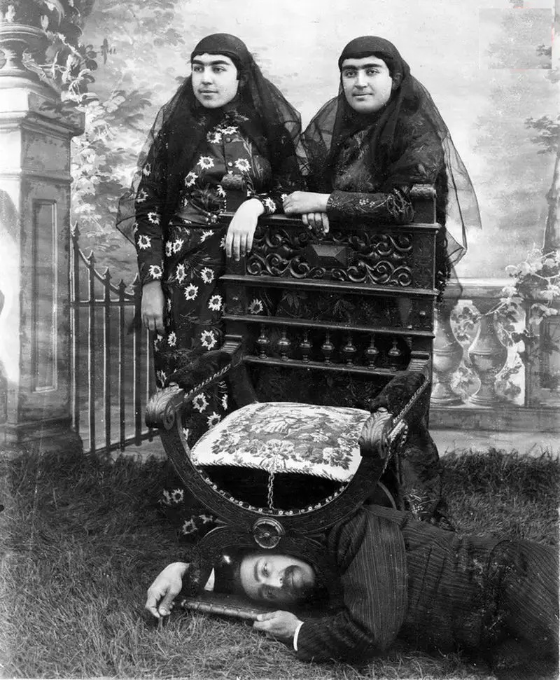 ژست عجیب &laquo;داماد ناصرالدین&zwnj;شاه&raquo; که در عکس اوسرش را زیر صندلی برده و دراز کشیده در حالی که بالای سر او دختران ناصرالدین شاه ایستاده اند