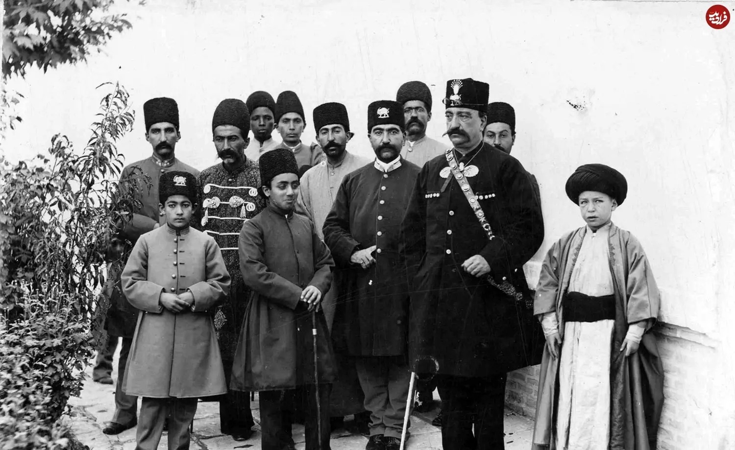 ناصرالدین شاه در کنار نوه اش، سید جواد امامی معروف به «ظهیرالاسلام» و فرزند احترام‌السلطنه که از پنج سالگی به کسوت روحانیت درآمد مشاهده خواهید کرد. در این تصویر ملیجک که لبخندی بر چهره دارد، کامران‌میرزا و عده‌ای از درباریان نیز حضور دارند.