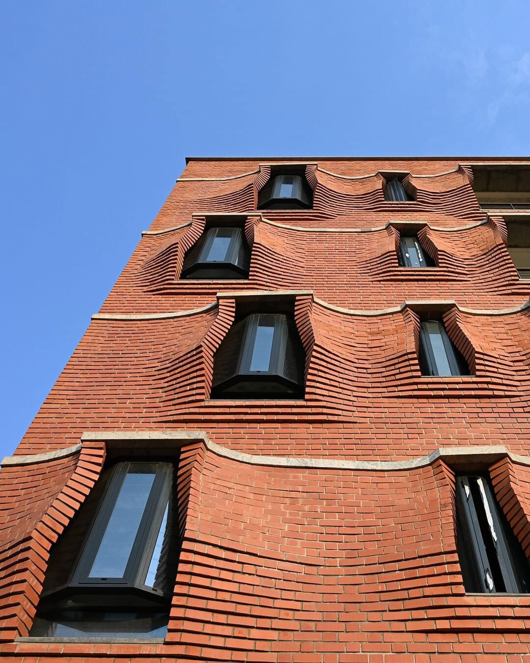 نمای نزدیک از آجرچینی پیش‌آمده و سایه‌بان‌های سنگی آپارتمان‌های سی‌ینا در حیدرآباد هند اثر سمیپ پادورا.