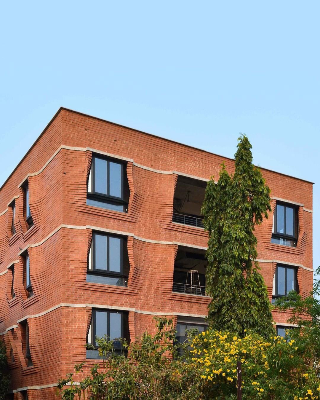 نمای نزدیک از آجرچینی پیش‌آمده و سایه‌بان‌های سنگی آپارتمان‌های سی‌ینا در حیدرآباد هند اثر سمیپ پادورا.