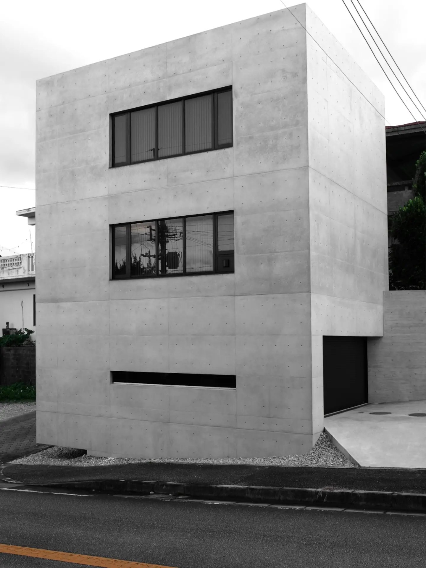 تصویر معماری نئو-بروتالیست یک خانه خصوصی در اوکیناوا با جزئیات بتنی و گوشه معلق سازه، عکاسی شده توسط بروتال ذن. تصویر معماری نئو-بروتالیست یک خانه خصوصی در اوکیناوا با جزئیات بتنی و گوشه معلق سازه، عکاسی شده توسط بروتال ذن.