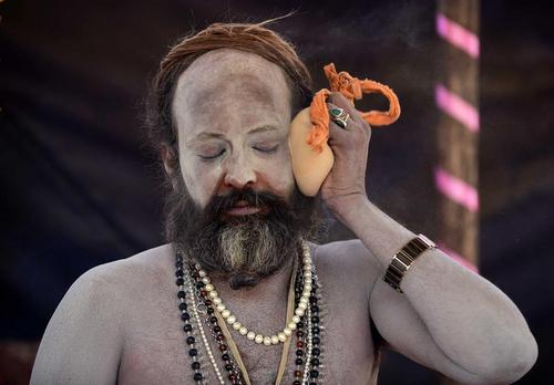 راهب هندو در حال مالیدن خاکستر به صورت در یک جشنواره آیینی در الله‌آباد هند